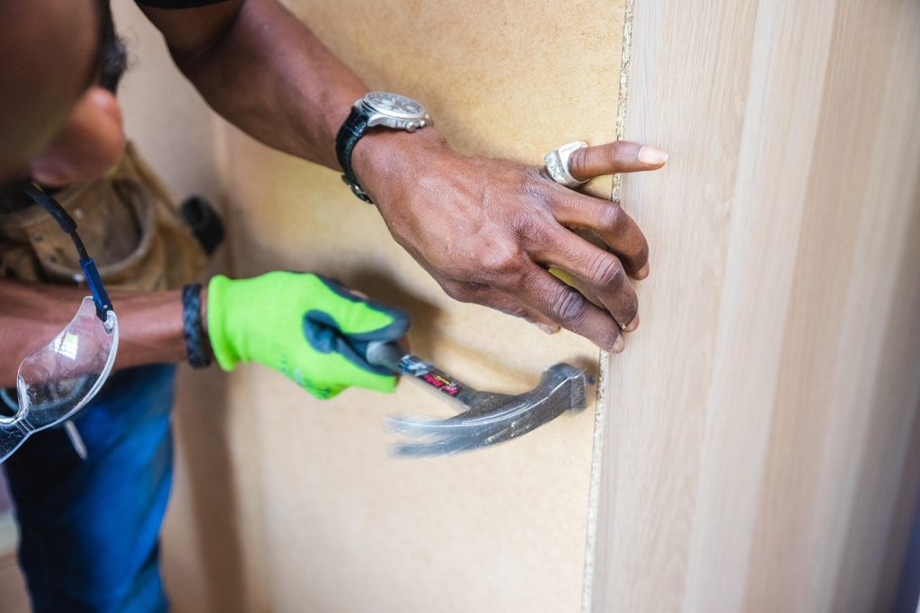 Man hammering a nail into a wall