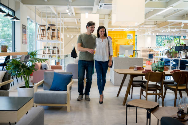 Man and woman shopping for living room furniture in a store